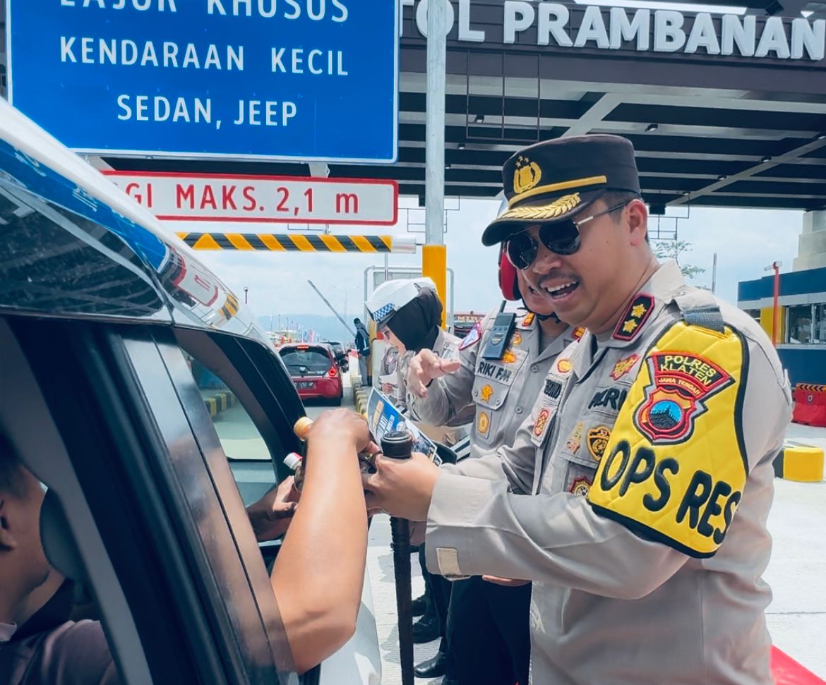 Kapolres Klaten AKBP Warsono membagikan snack dan selebaran informasi lalu lintas di Gerbang Tol Prambanan Klaten dalam Operasi Lilin Candi 2024. (Angga Purenda/Radar Solo)