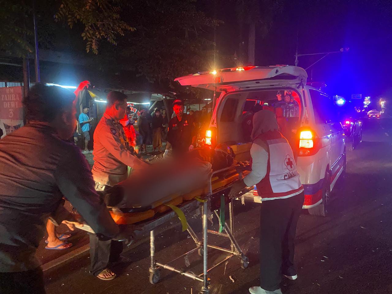 Petugas mengevakuasi pengendara motor yang bertabrakan dengan bus Rosalia Indah di Ngrampal, Sragen, Senin (30/12/2024) dini hari.