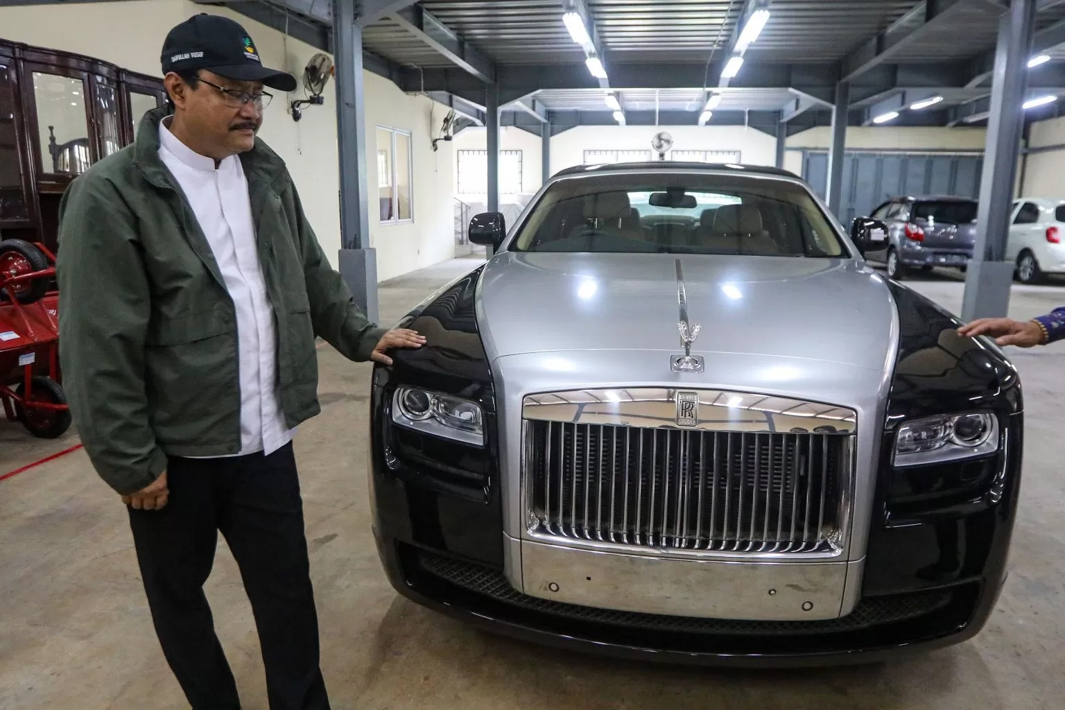 MASIH MULUS: Saifullah Yusuf mengecek kondisi mobil mewah Rolls-Royce yang masuk kategori hadiah tak bertuan di gedung konvensi di TMPNU Kalibata kemarin (30/12).