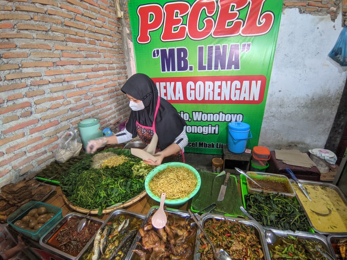 Mbak Lina melayani pesanan pelanggan. Menu pecel di warung ini banyak digandrungi.