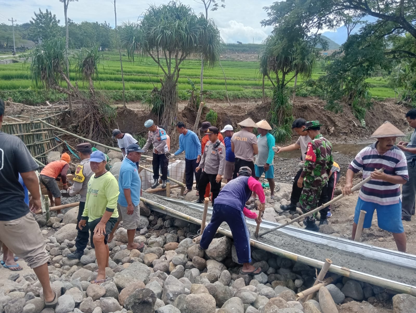 Warga dibantu TNI dan polri membangun jembatan darurat di Winong penghubung Sragen dan Ngawi yang ambrol diterjang banjir. (Ahmad Khairudin/Radar Solo)