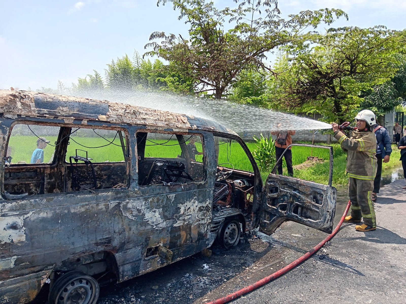 Petugas Damkar Klaten padamkan mobil yang terbakar di Desa Wonosari, Kecamatan Trucuk, Klaten, Selasa (21/1/2025).