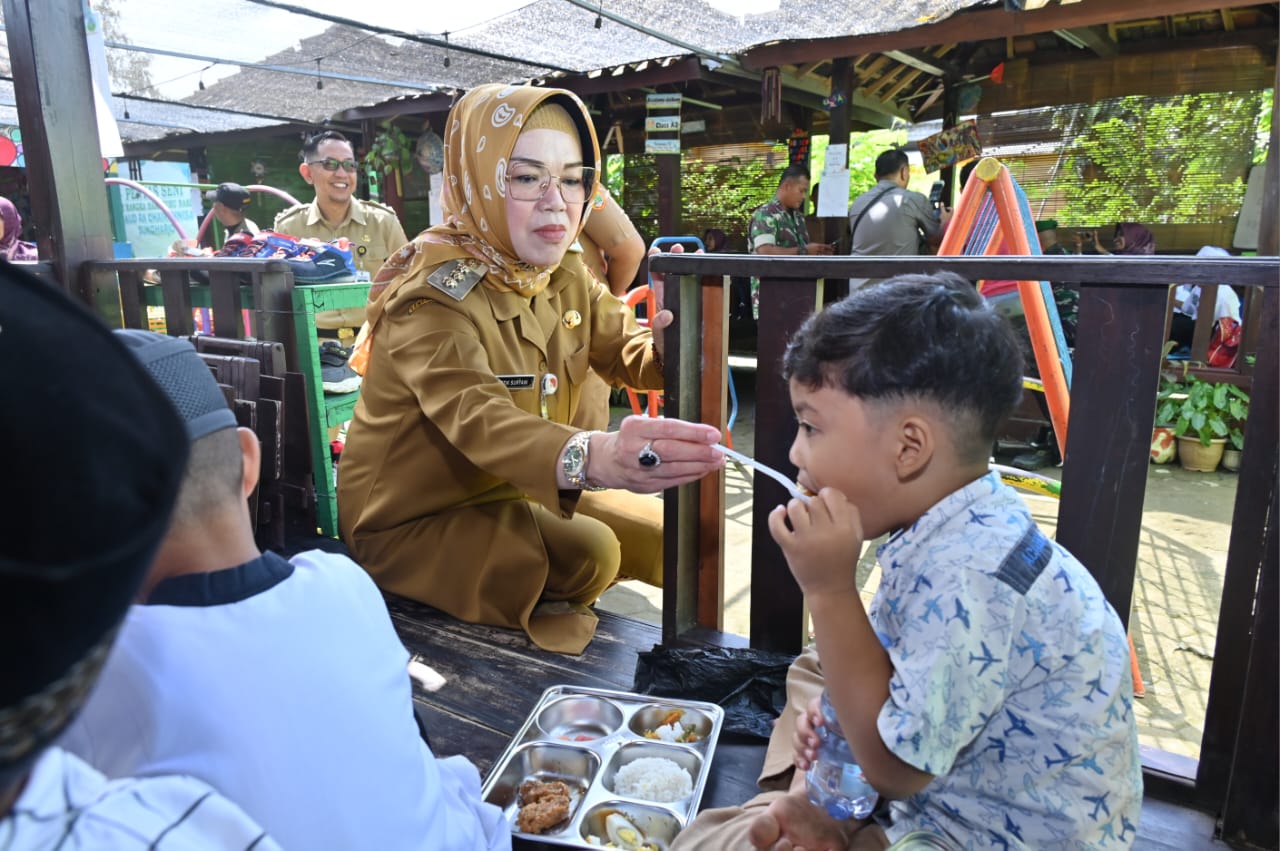 Bupati Sukoharjo Etik Suryani menyuapi siswa dengan menu makan bergizi gratis belum lama ini.