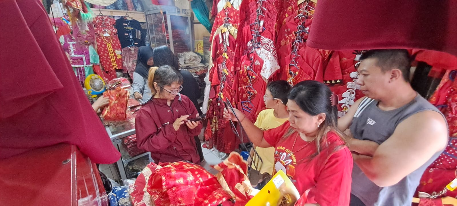 MERAH MENYALA: Baju cheongsam di Pasar Gede Solo laris diburu masyarakat jelang Imlek, Kamis (23/1).