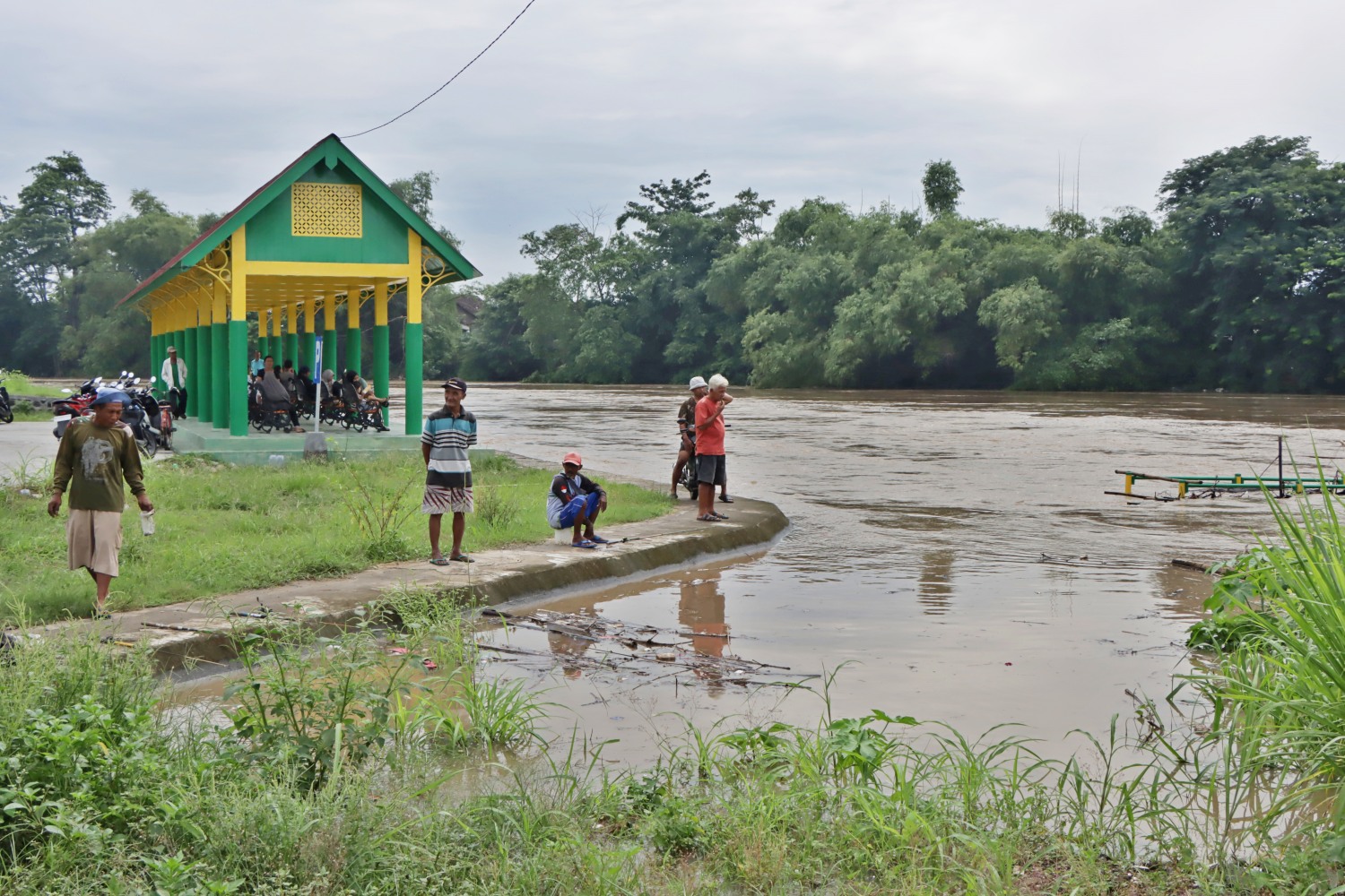 JADI TONTONAN: Derasnya arus Sungai Bengawan Solo menarik perhatian warga untuk melihat dari tanggul di Kampung Beton, Kelurahan Sewu, Kecamatan Jebres, kemarin (23/1).