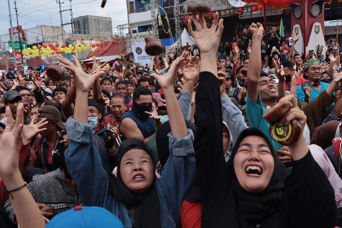 Warga berebut 4.000 kue keranjang yang disebar pada event Grebeg Sudiro, Minggu (26/1/2025).