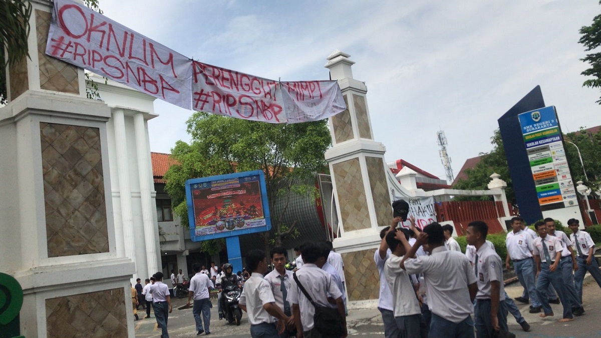 Spanduk bernada kekecawaan dipasang di gerbang SMKN 2 Solo.