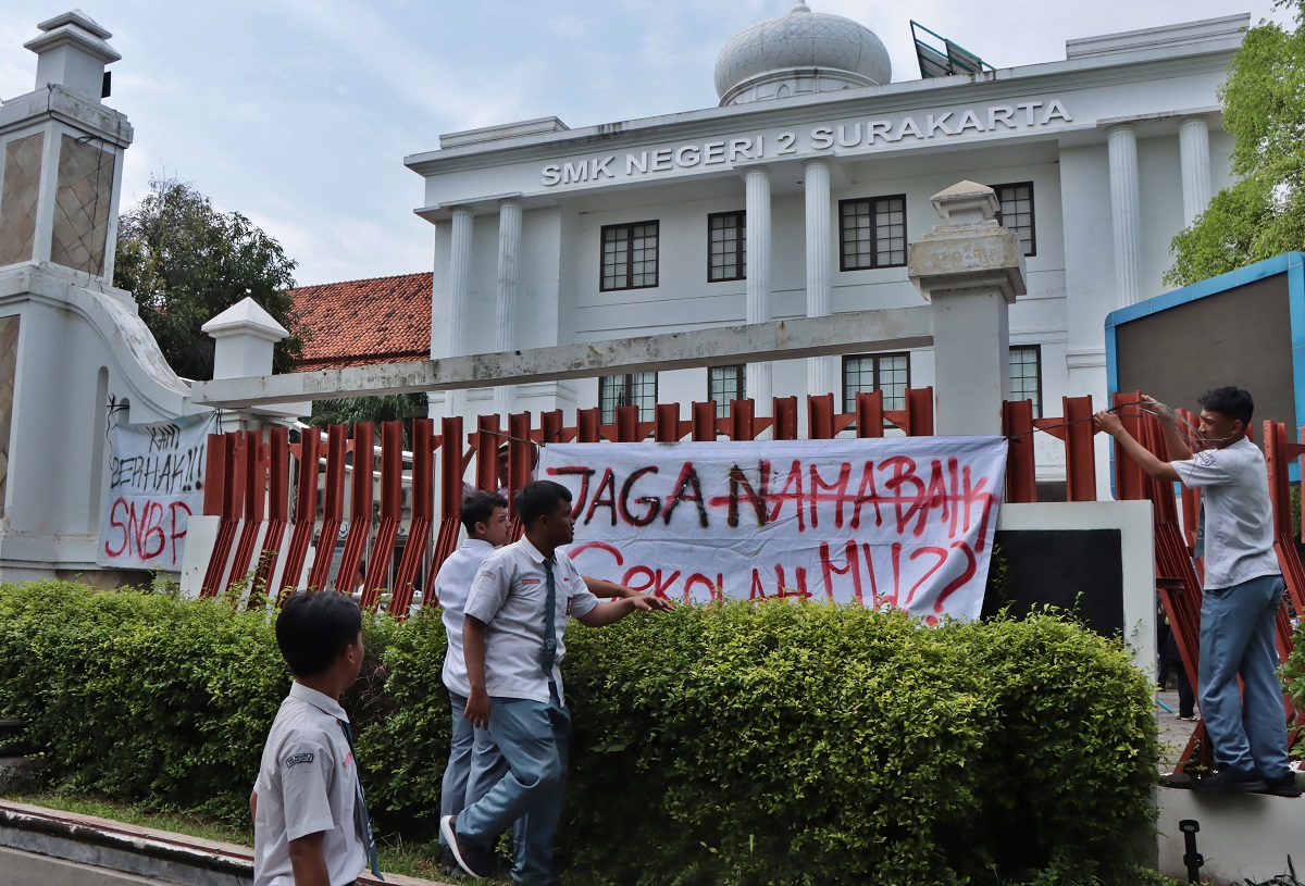 Siswa SMKN 2 Solo memasang spanduk bernada protes karena terancam tak bisa daftar SNBP akibat kelalaian sekolah, Senin (3/2/2025).