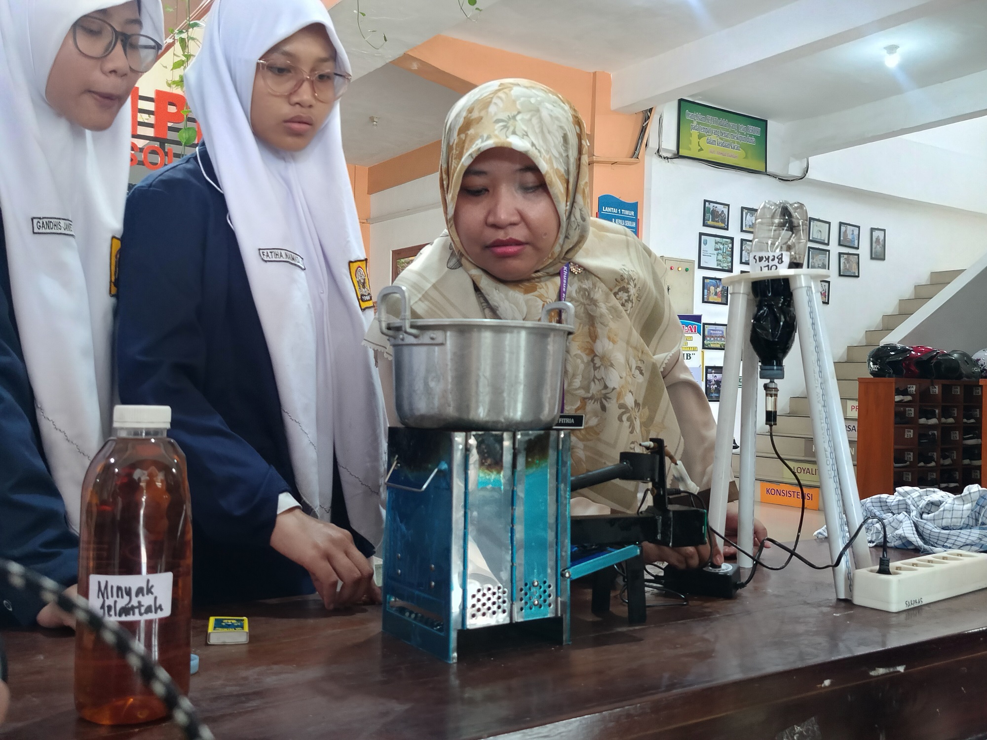 Guru IPA Nurul Fitria bersama siswanya mempraktikkan cara menghidupkan kompor dari bahan oli bekas. (Fauziah Akmal/Radar Solo)