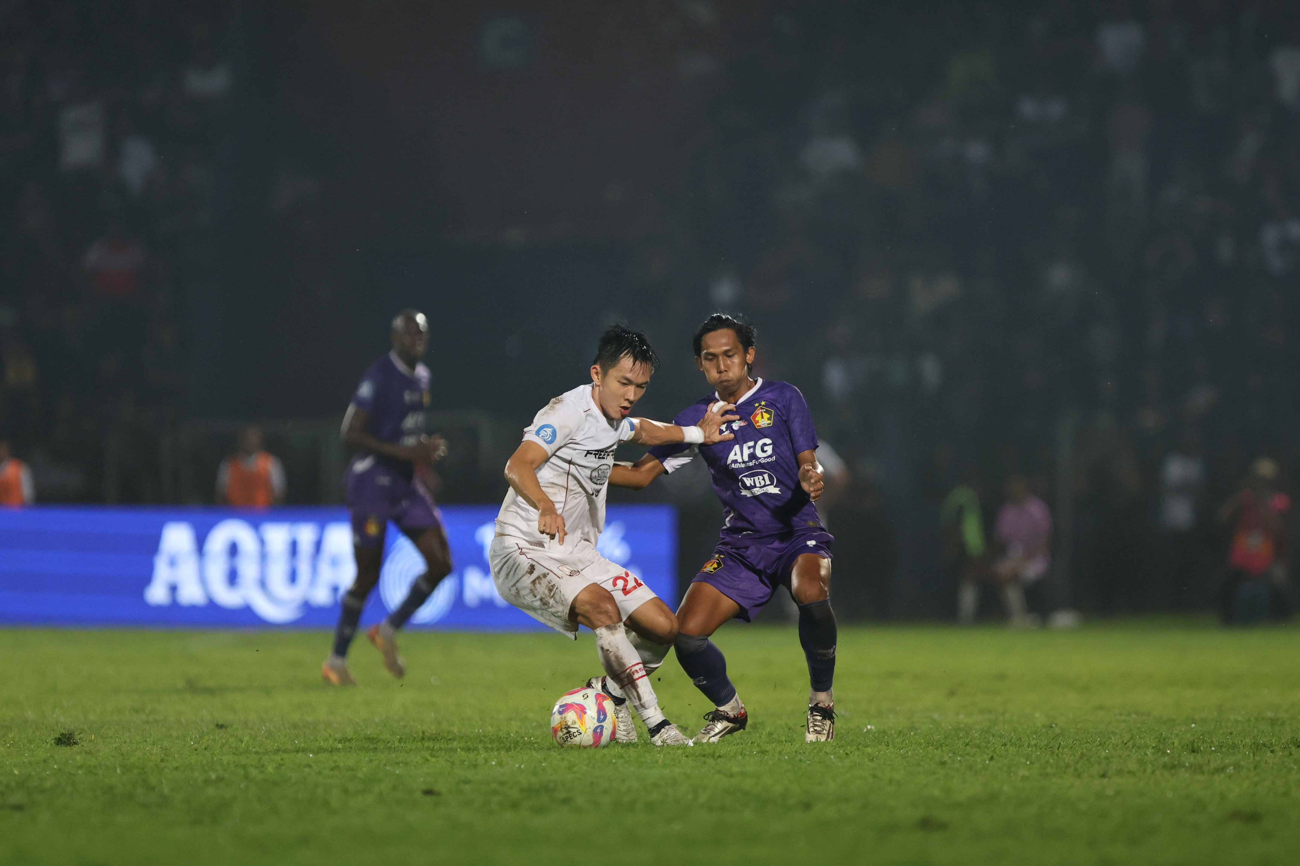 Gelandang Persis Solo Sutanto Tan dikawal ketat pemain Persik Kediri di Stadion Brawijaya, Jumat malam (14/2).