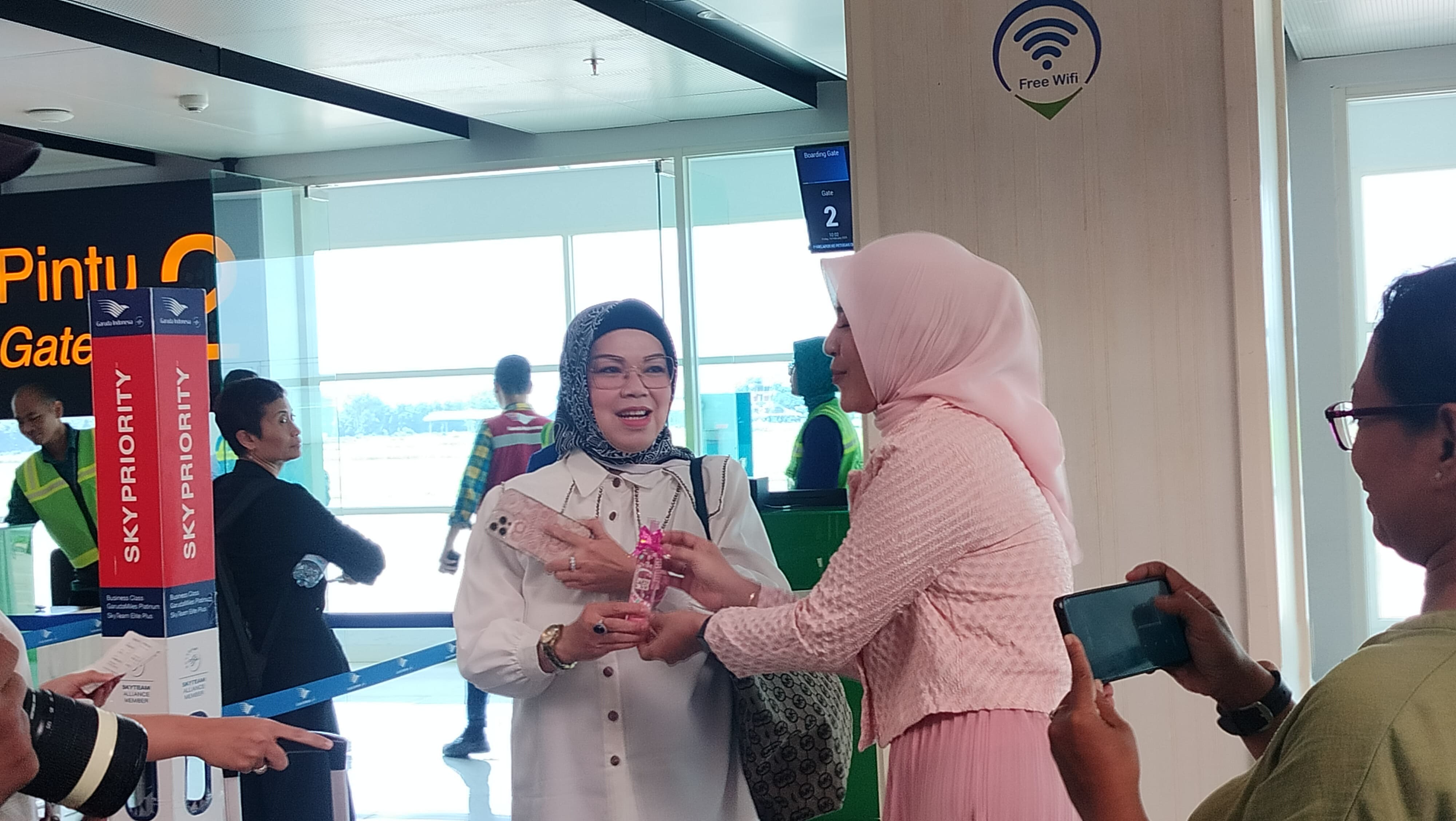 Karyawan PT Mandom Indonesia Tbk Cabang Solo membagikan cokelat dan produk pixy kepada calon penumpang pesawat di Bandara Adi Sumarmo Solo. Salah satunya Bupati Sukoharjo Etik Suryani.