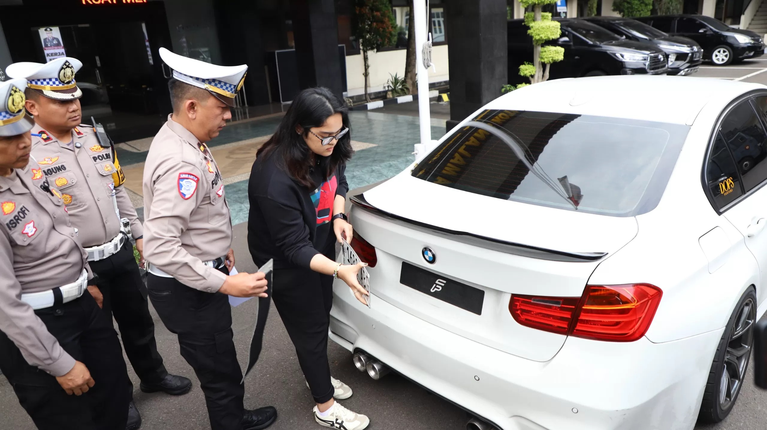 Pengemudi mobil BMW yang menggunakan pelat nomor palsu dengan tulisan tidak senonoh saat diamankan Satlantas Polresta Malang Kota.