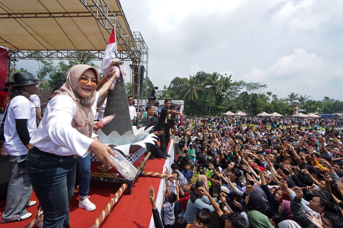 Bupati Klaten Sri Mulyani menyebarkan boks berisi buah durian di Lapangan Merdeka Desa Randulanang, Kecamatan Jatinom, Klaten, Minggu (16/2/2025).
