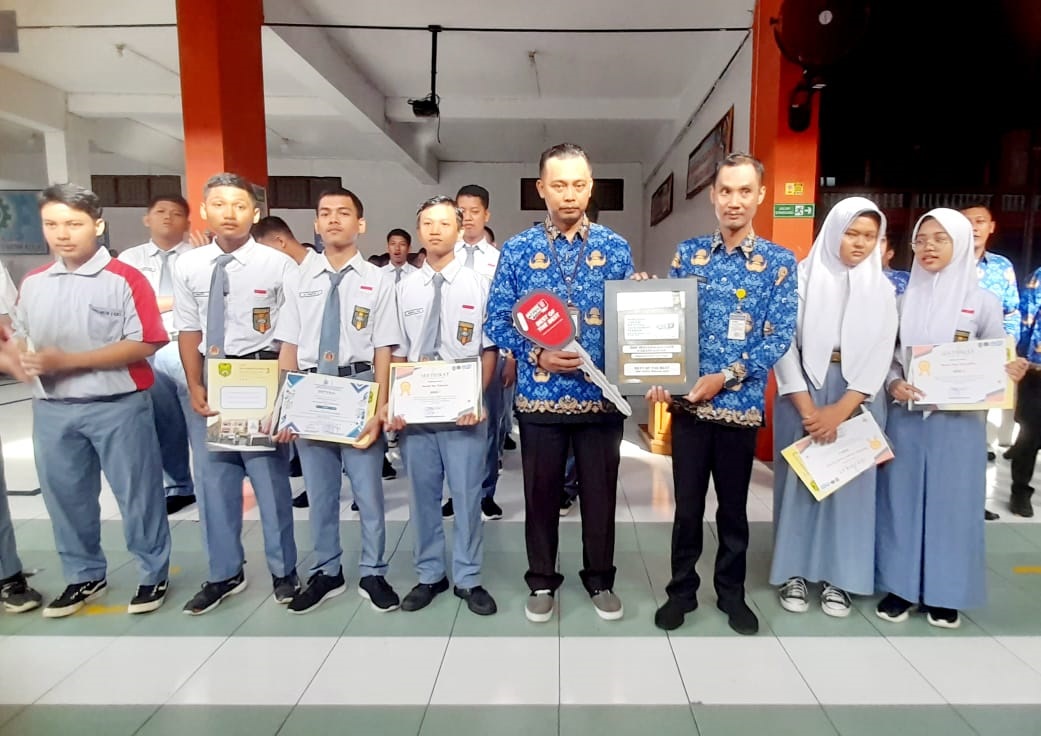 DEDIKASI: Perwakilan dari guru program otomotif SMK Muhammadiyah 3 Karanganyar saat menerima secara simbolis berupa kunci, sebagai predikat Best of The Best SMK Mitra Binaan AHM.