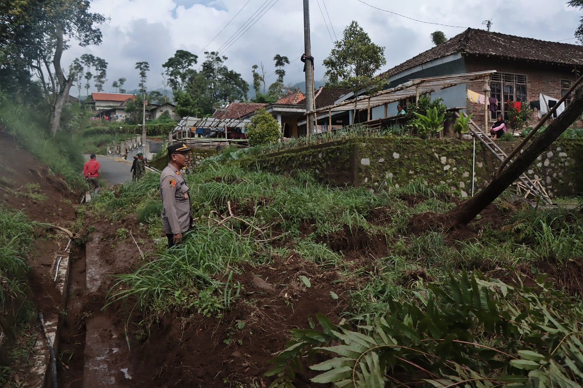 Material tanah bercampur batu menutup akses jalan desa.