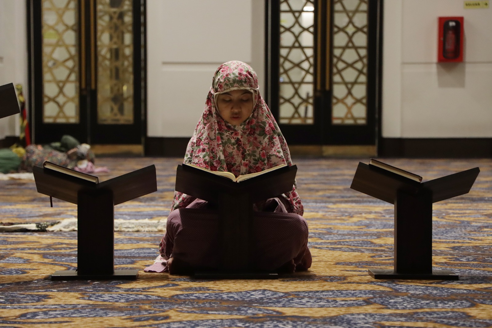 KHUSYUK: Seorang wanita tengah membaca Alquran di Masjid Zayed. Masjid ini jadi salah satu rujukan jamaah, termasuk saat momen bulan Ramadan.