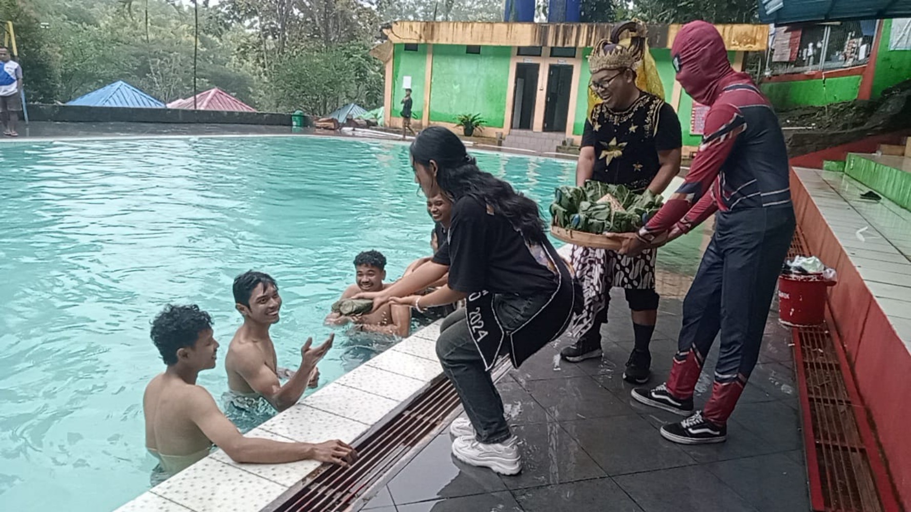 PEDULI: Sejumlah tokoh superhero bagikan nasi berkat di kolam renang Batu Seribu, belum lama ini.