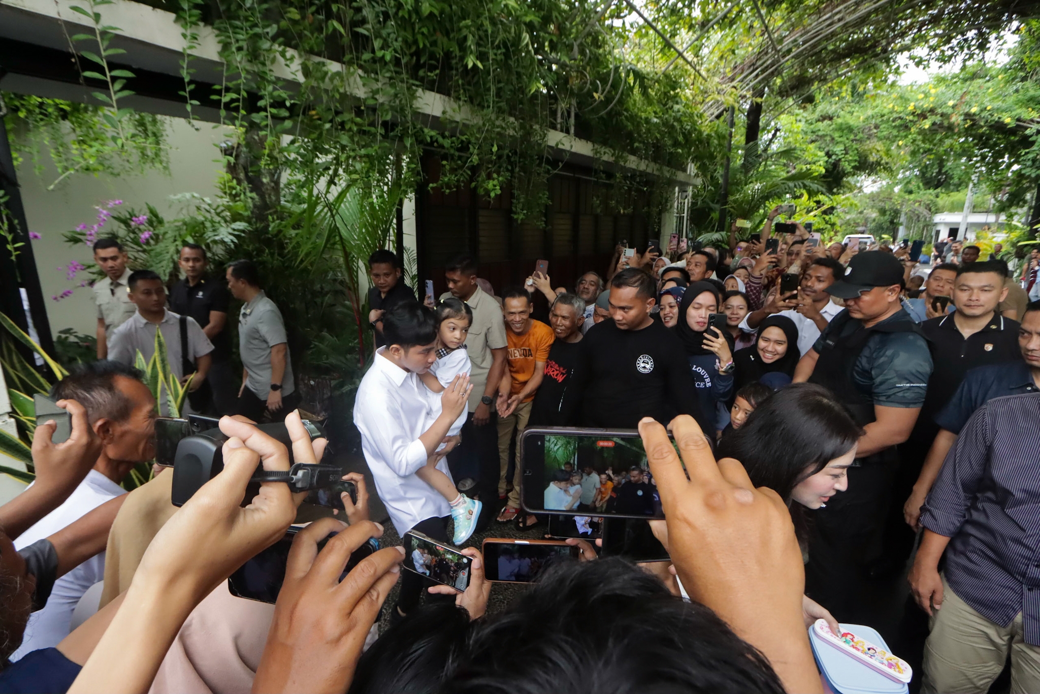 Wapres Gibran Rakabuming Raka beri salam kepada masyarakat saat tiba di rumah Jokowi, Selasa (1/3).