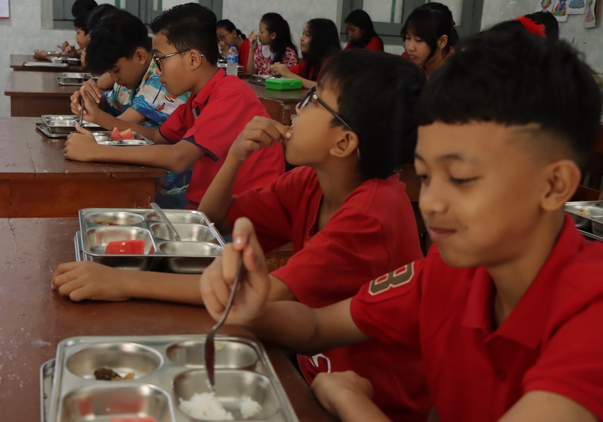 Ilustrasi siswa di Kota Solo menikmati menu MBG.