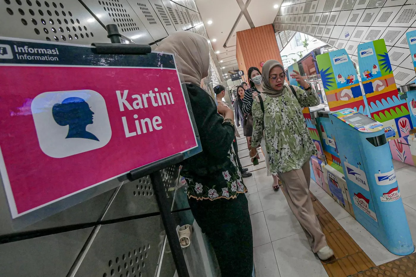 Sejumlah penumpang perempuan melintas di gate Halte TransJakarta Bundaran HI, Jakarta, Senin (21/4/2025).