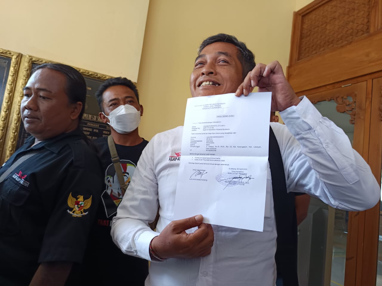 Relawan Alap Alap Jokowi tunjukkan surat tanda terima aduan terkait tudingan ijazah palsu di Mapolresta Solo, Rabu (30/4/2025).