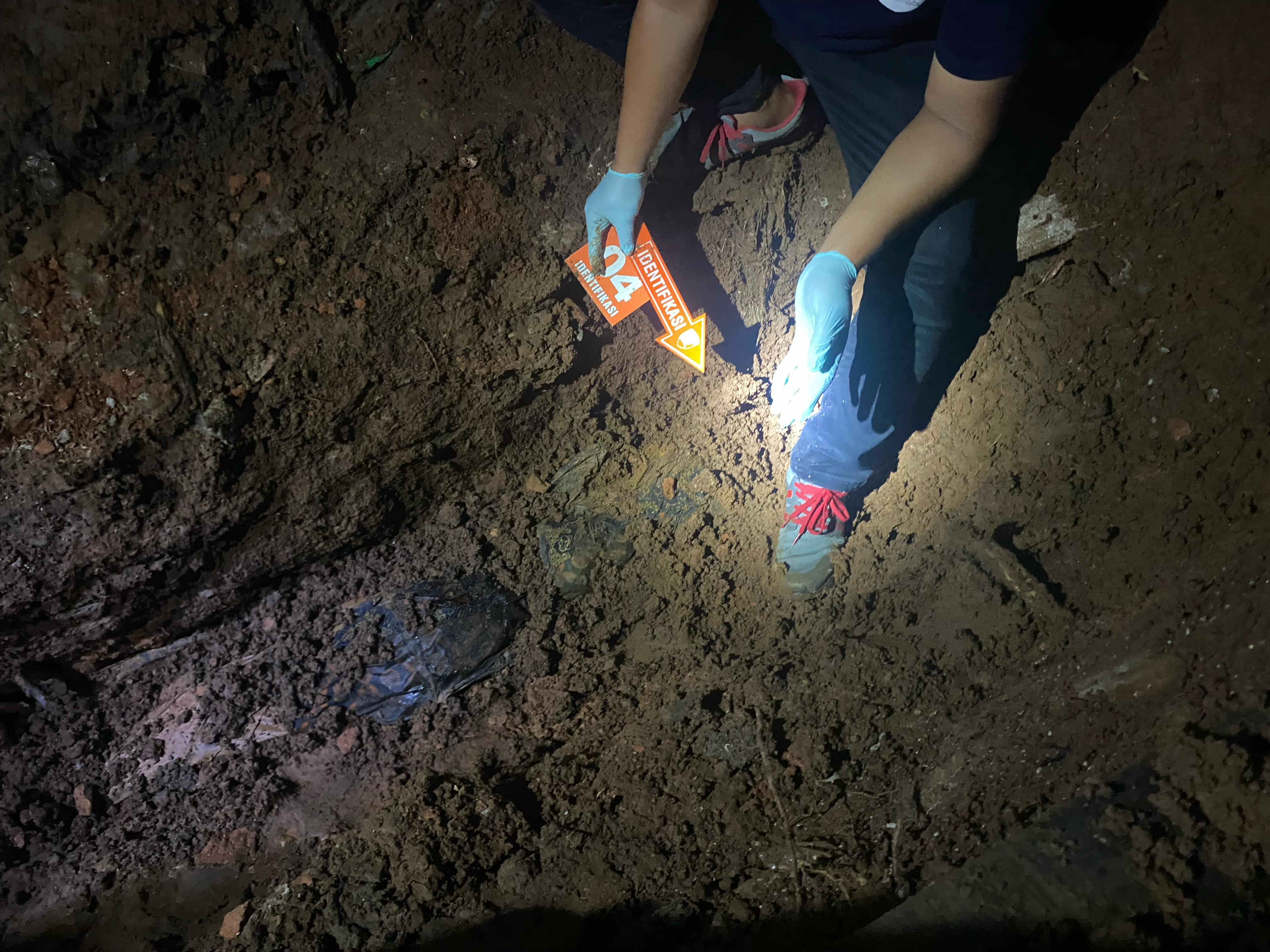 Polisi saat membongkar liang lahat tempat J mengubur dan mengecor mayat Dwi Hastuti di Ngadirojo, Wonogiri, Jumat (2/5/2025).