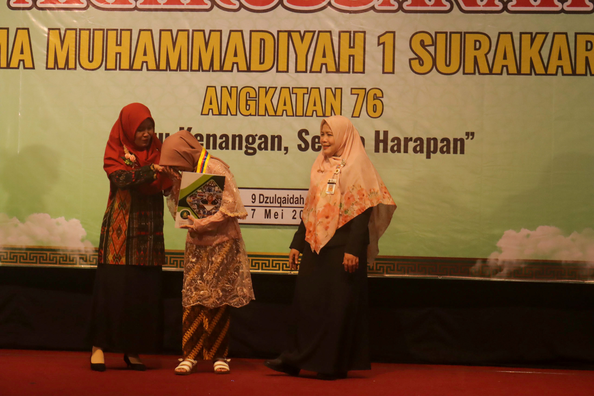Kepala SMA Muhammadiyah 1 Surakarta Rahayuningsih (kanan) serahkan siswa ke orang tua saat Akhirussanah Angkatan Ke-76 di Graha Saba Buana, Rabu (7/5).