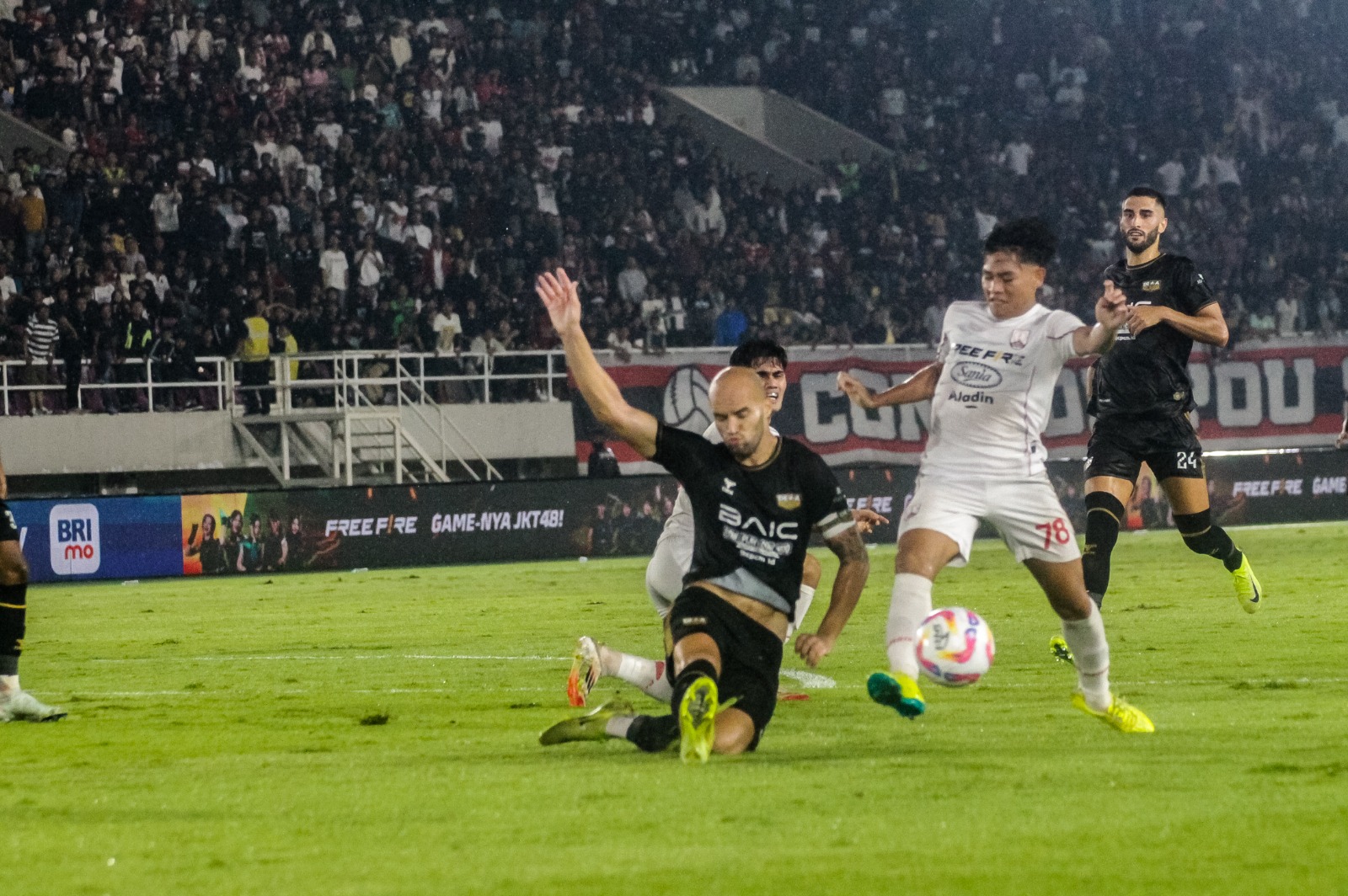CEKATAN: Gelandang Persis Solo Zanadin Fariz (kanan) hendak dijegal bek Dewa United di Stadion Manahan, Sabtu malam (17/5).