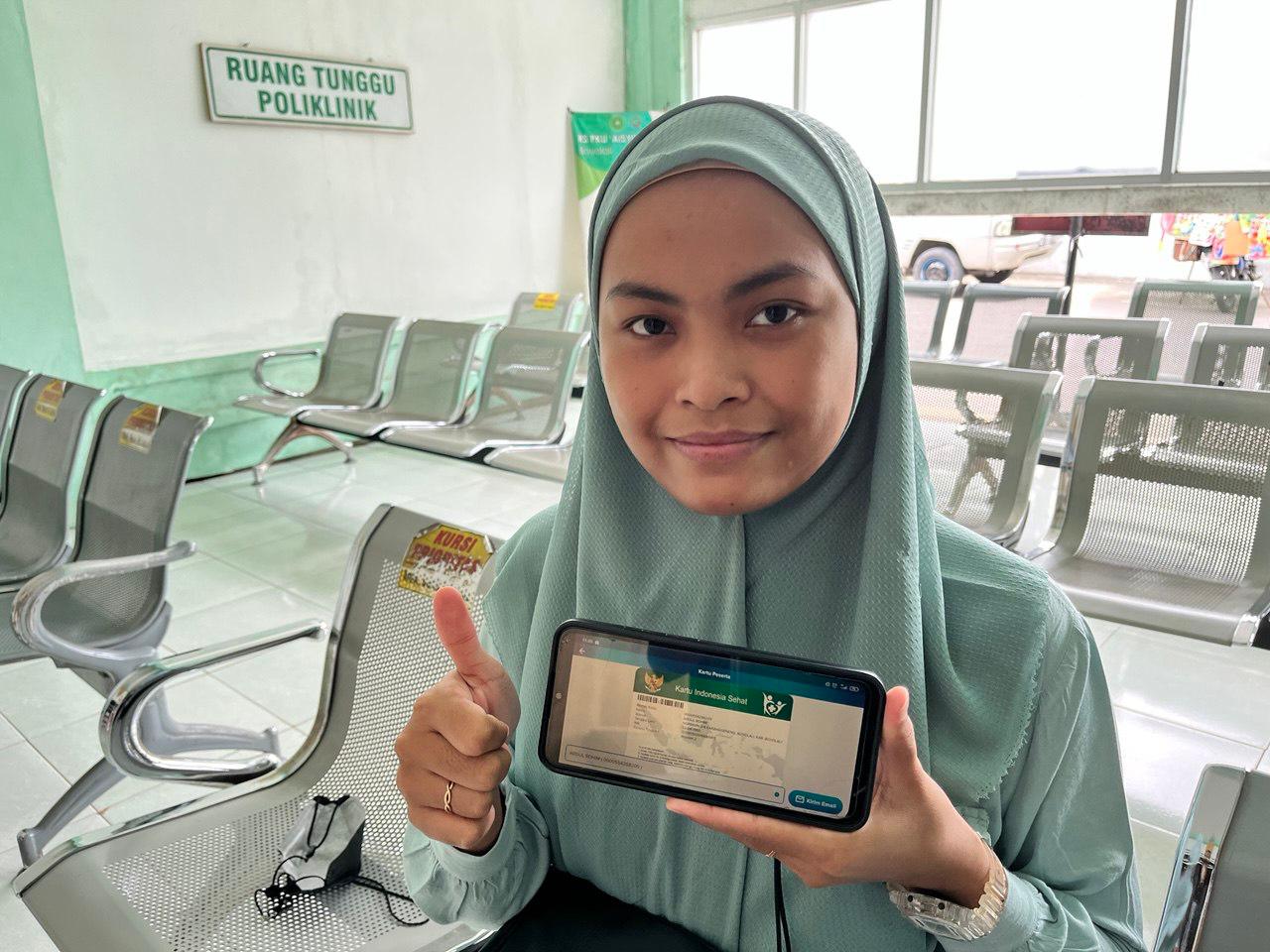 Siti memperlihatkan kartu kepesertaan Jaminan Kesehatan Nasional (JKN) miliknya.