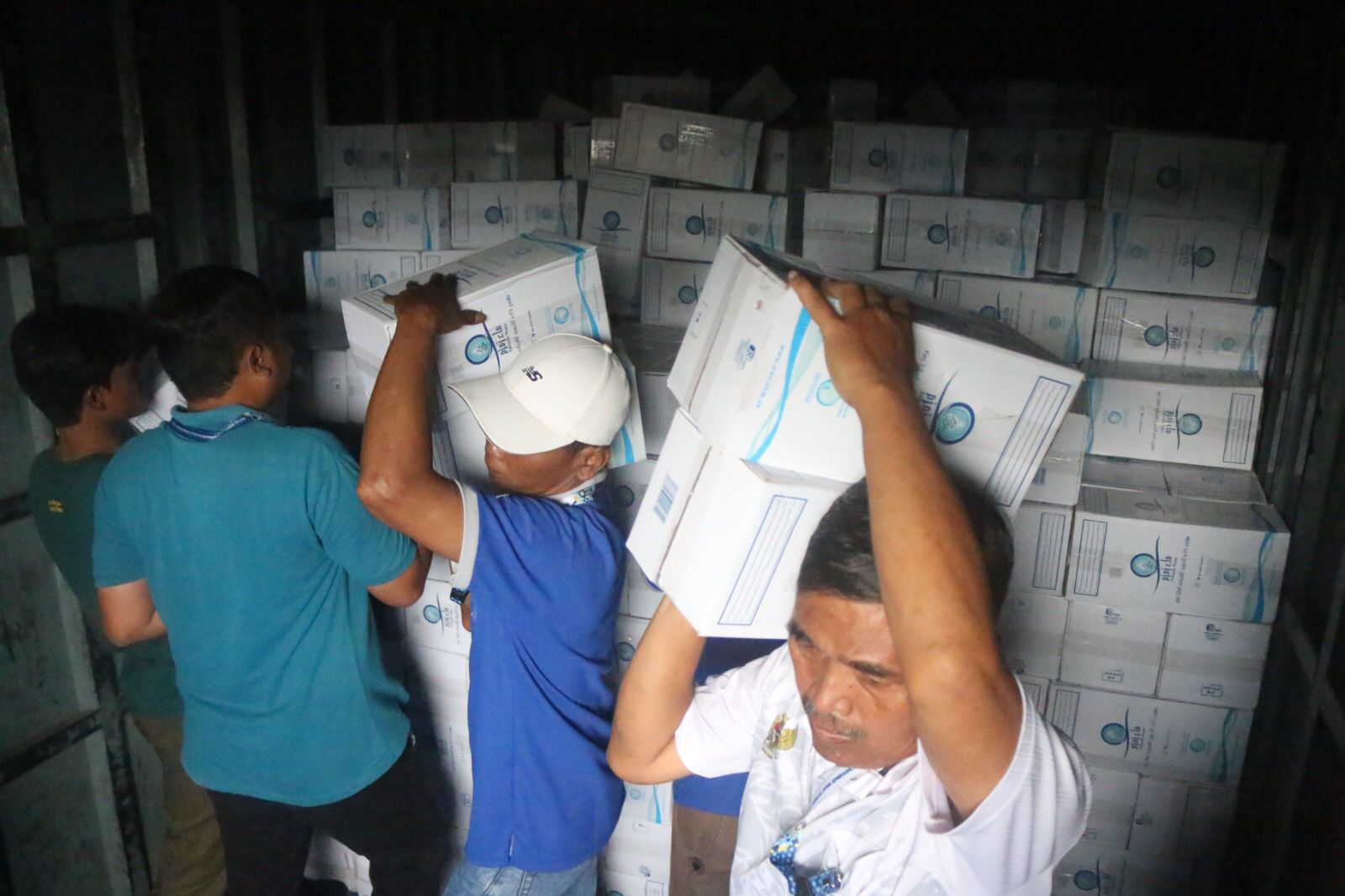 Petugas di Embarkasi Solo menurutkan kardus berisi air zamzam yang akan dibagikan kepada jemaah haji, Kamis (22/5/2025).