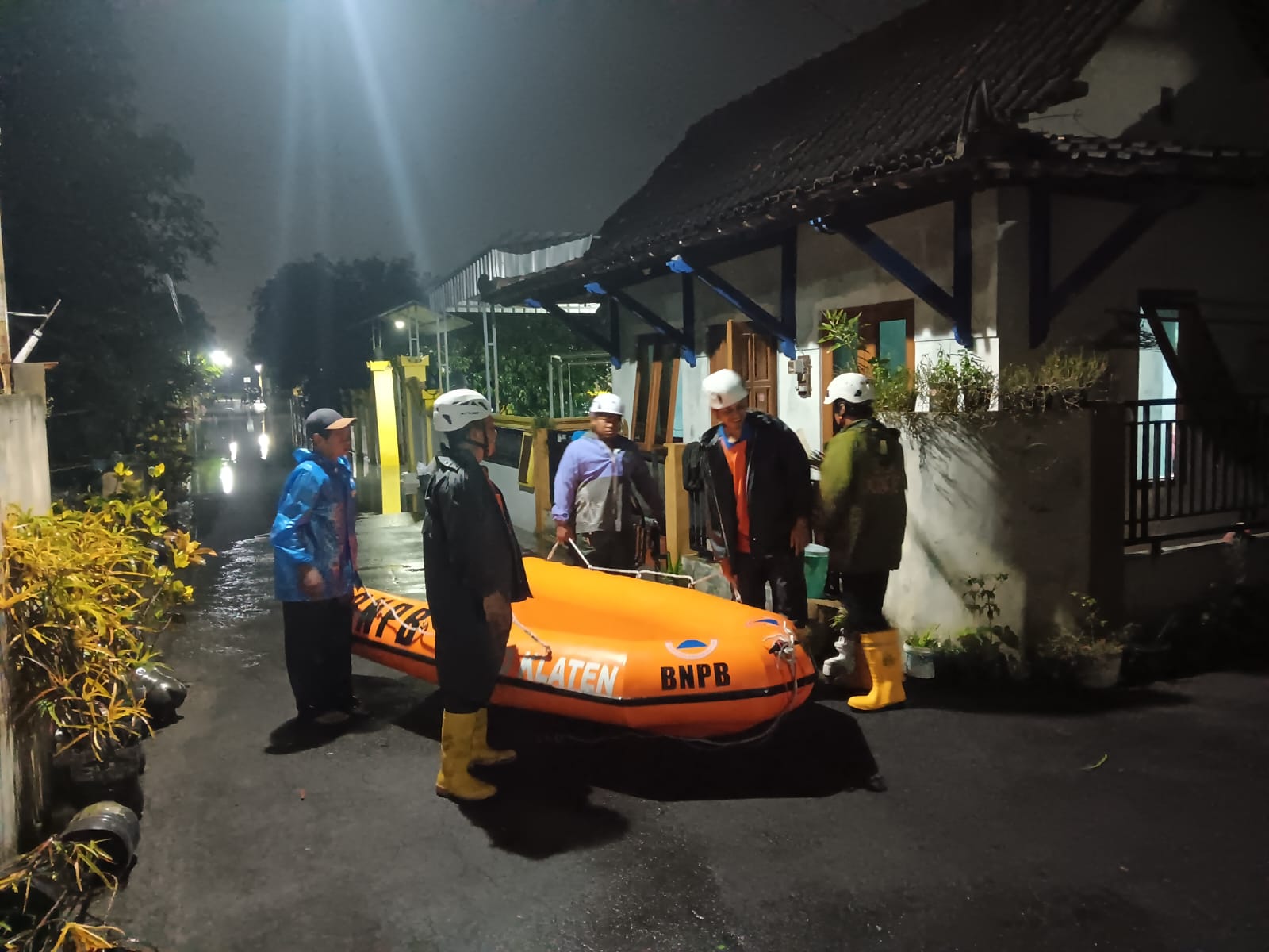 Tim dari BPBD Klaten saat menyiagakan perahu karet di wilayah Kelurahan Gumulan, Klaten Tengah yang sempat dilanda banjir, Kamis (22/5/2025) malam. (Angga Purenda/Radar Solo)