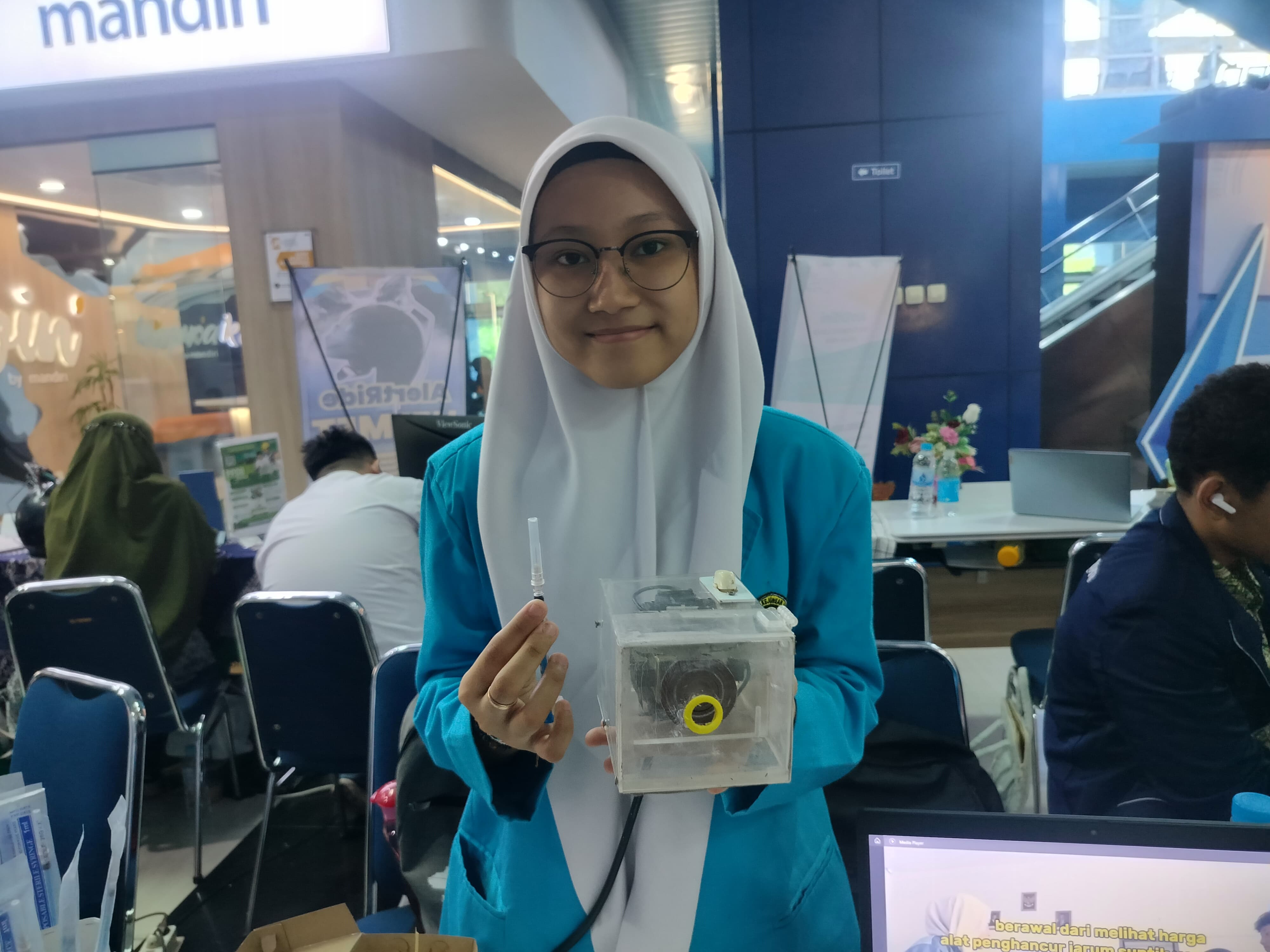 Siswa SMK Analis Kesehatan Nasional Solo tunjukkan alat penghancur jarum suntik.