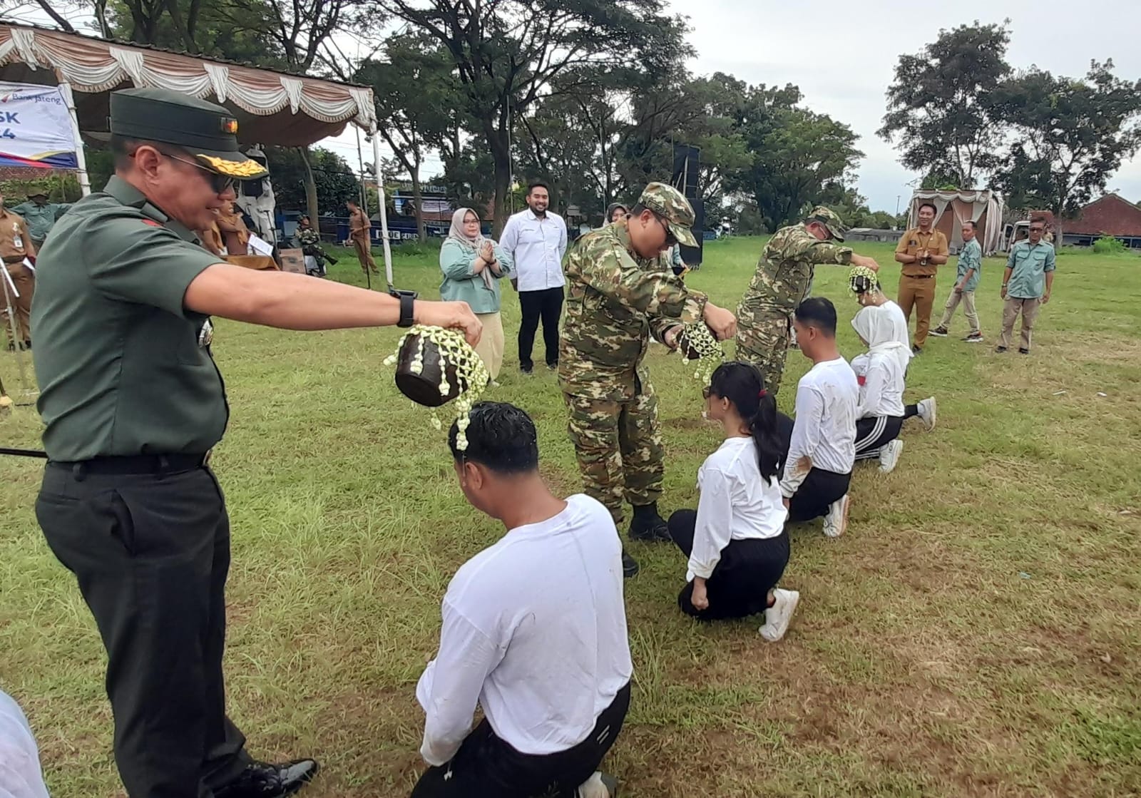 Dari kiri Dandim 0727/Karanganyar Letkol Kav. Dhanang Prasetyo Kurniawan, Wabup Karanganyar Adhe Eliana, dan Bupati Karanganyar Rober Christanto menyiram air kendi ke CPNS. (Rudi Hartono/Radar Solo)