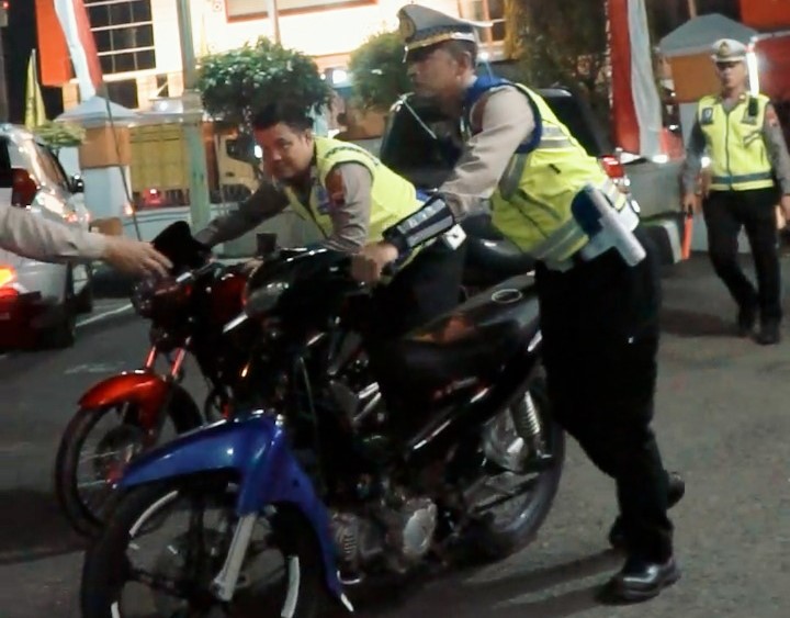 Anggota Satlantas Polres Sragen mengamankan sepeda motor berkalpot brong yang memprovokasi saat pendadaran perguruan silat, Minggu (25/5/2025) malam. (Ahmad Khairudin/Radar Solo)