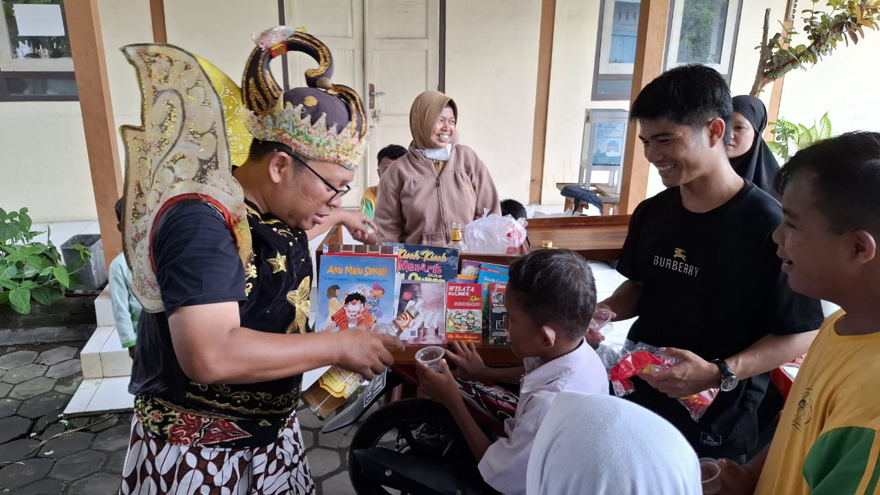 Aktivis sosial Agus Widanarko mengenakan kostum Gatotkaca, membagikan jamu kepada ABK di salah satu SLB di Desa Langenharjo, Kecamatan Grogol, Selasa (27/5).