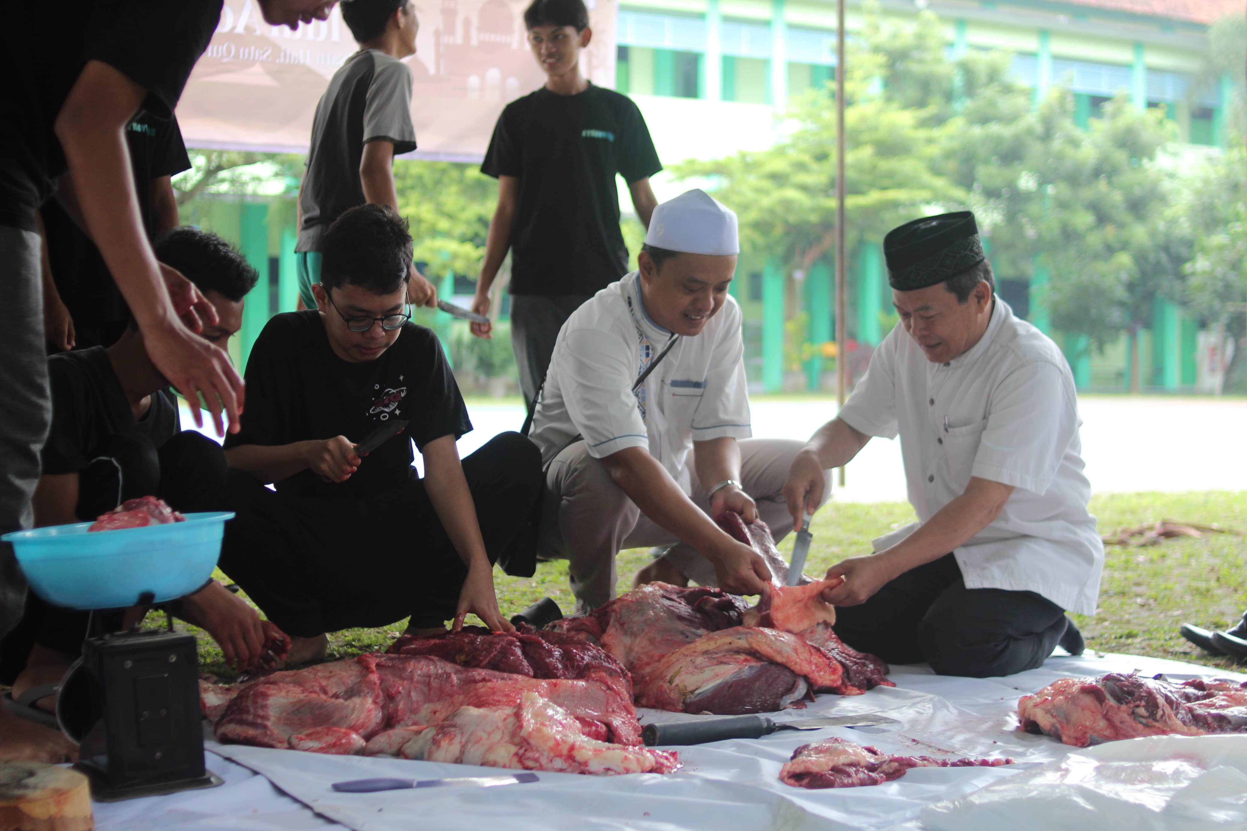 Pelaksana Tugas (Plt) Kepala SMAN 3 Klaten Tukimin (kanan) saat melaksanakan pemotongan daging kurban bersama siswa di lapangan sekolah setempat.&nbsp;