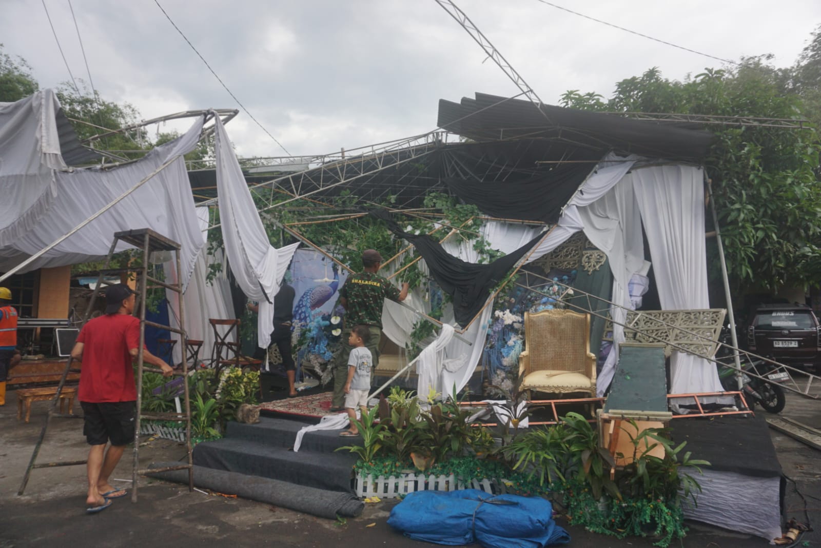 Relawan bersama warga melakukan penanganan terhadap tenda hajatan yang porak poranda usai disapu angin kencang di Desa Sawahan, Kecamatan Juwiring, Klaten, Sabtu (14/6/2025).