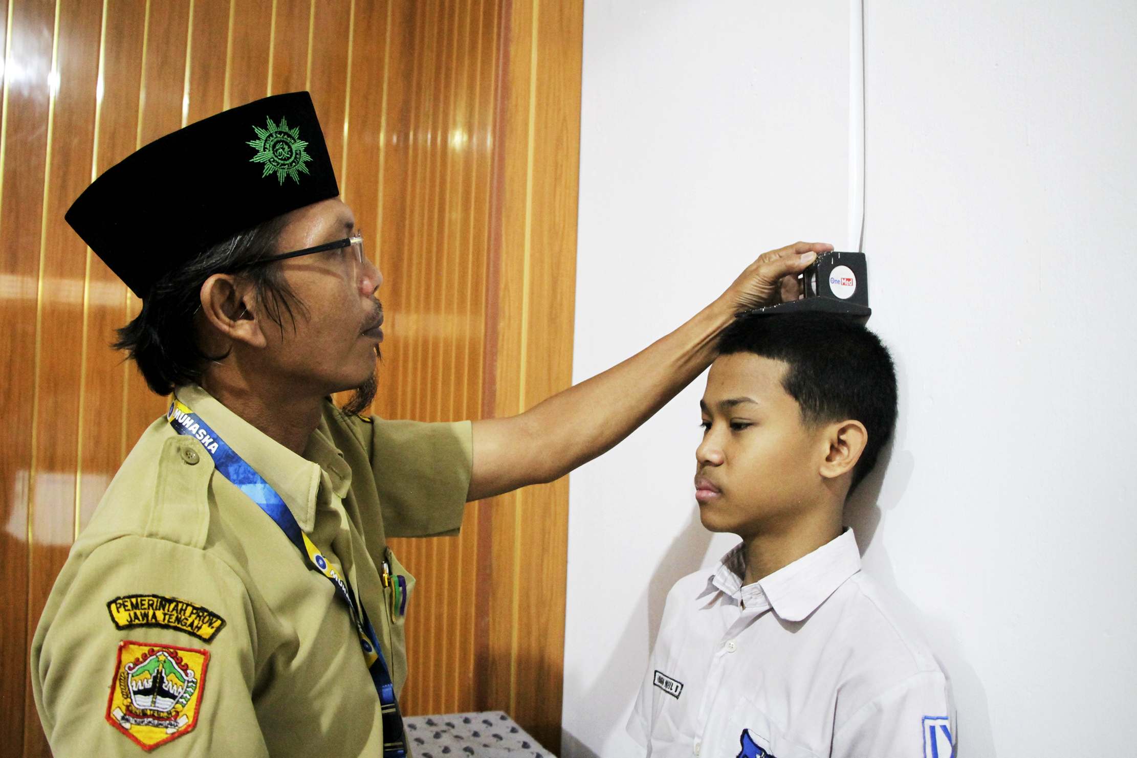 Calon peserta didik diukur tinggi badannya oleh guru, dalam program kemitraan SPMB 2025 di SMA Muhammadiyah 2 Solo, Senin pagi (16/6).