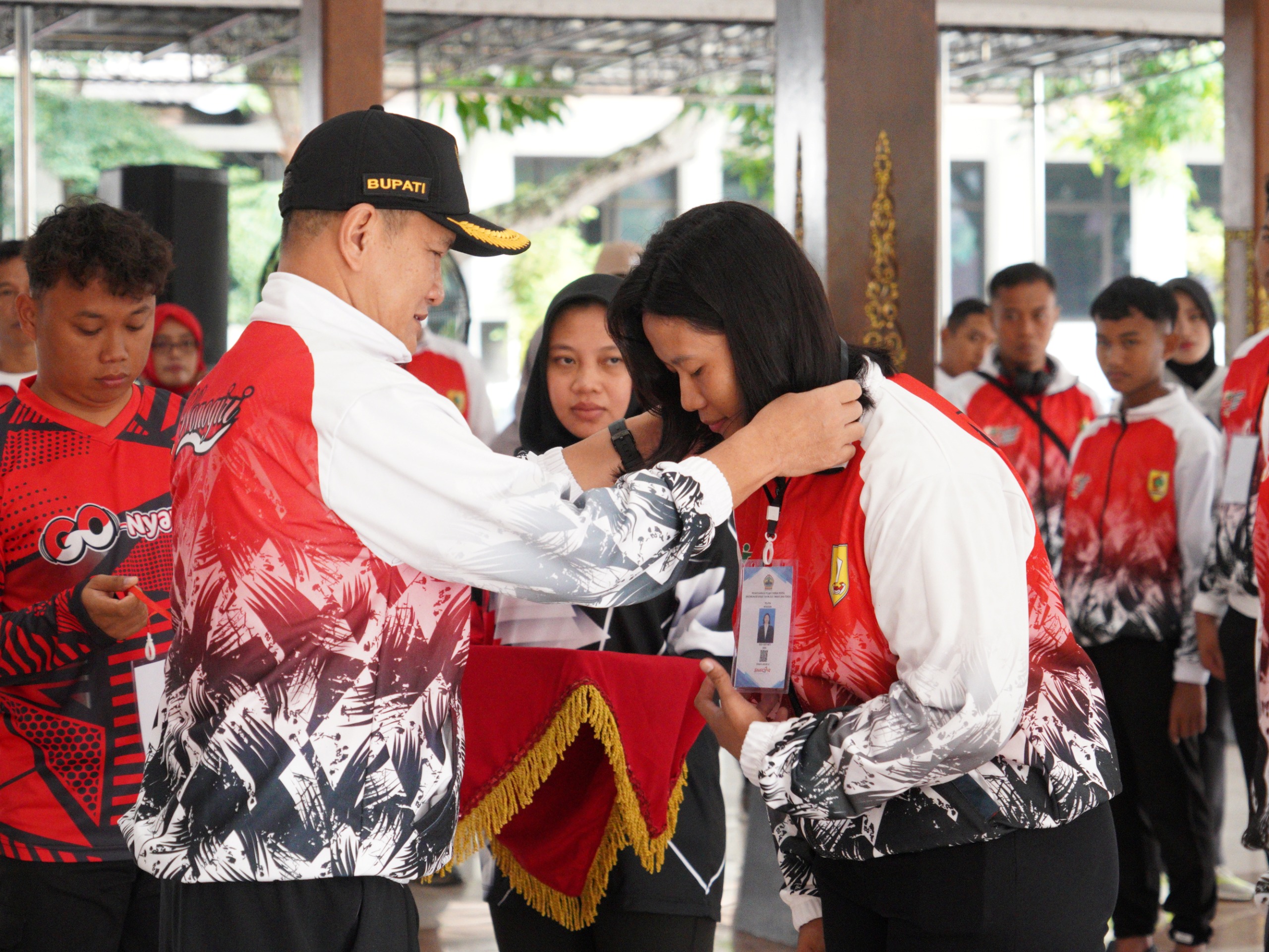 Bupati Wonogiri Setyo Sukarno mengalungkan id card kepada perwakilan atlet saat pemberangkatan atlet POPDA SMA/sederajat tingkat provinsi, Senin (16/5/2025).
