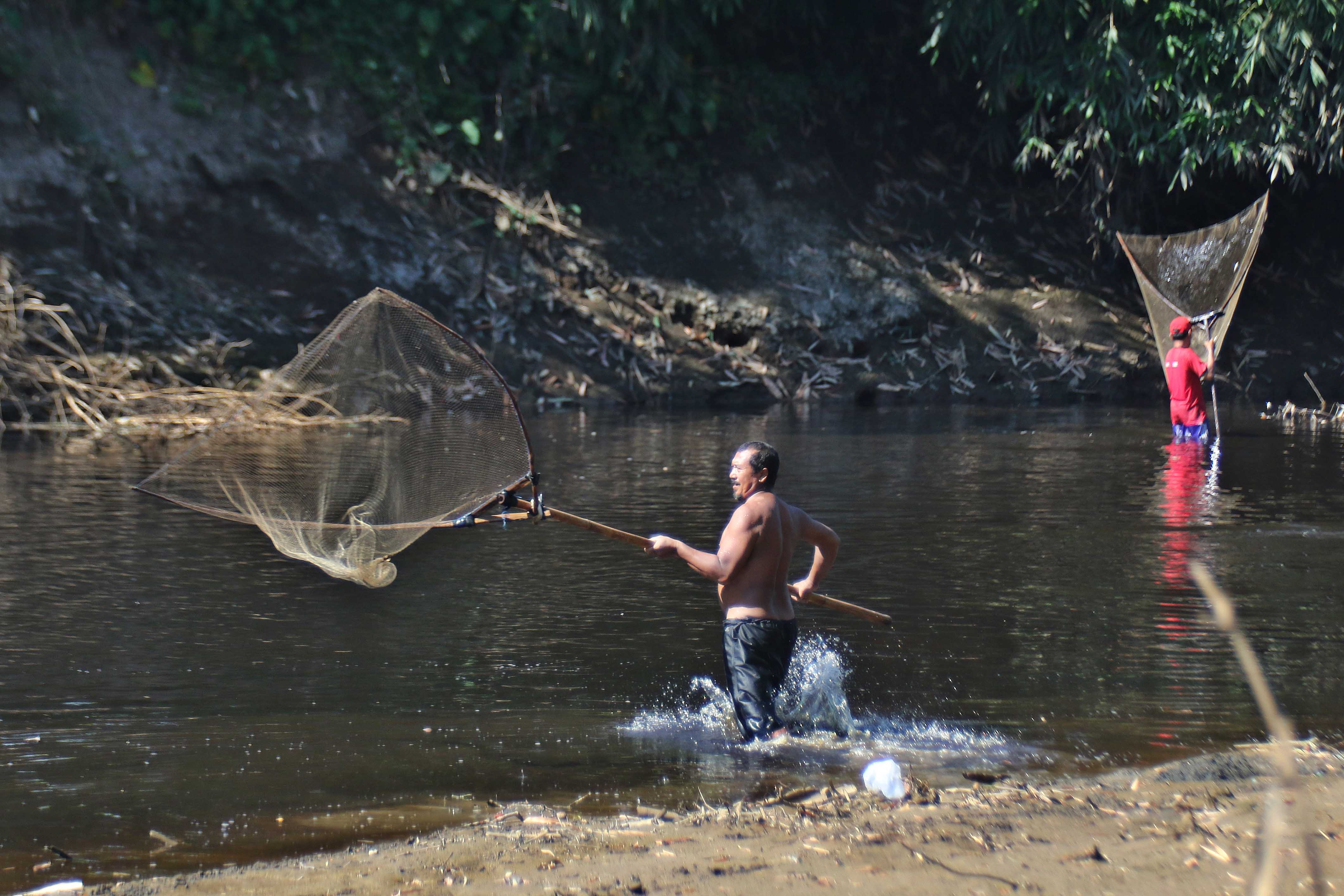 Warga menjaring ikan di Sungai Samin dengan muara di Sungai Bengawan Solo usai tercemar limbah etanol di Desa Kadokan, Kecamatan Grogol, Sukoharjo, belum lama ini.