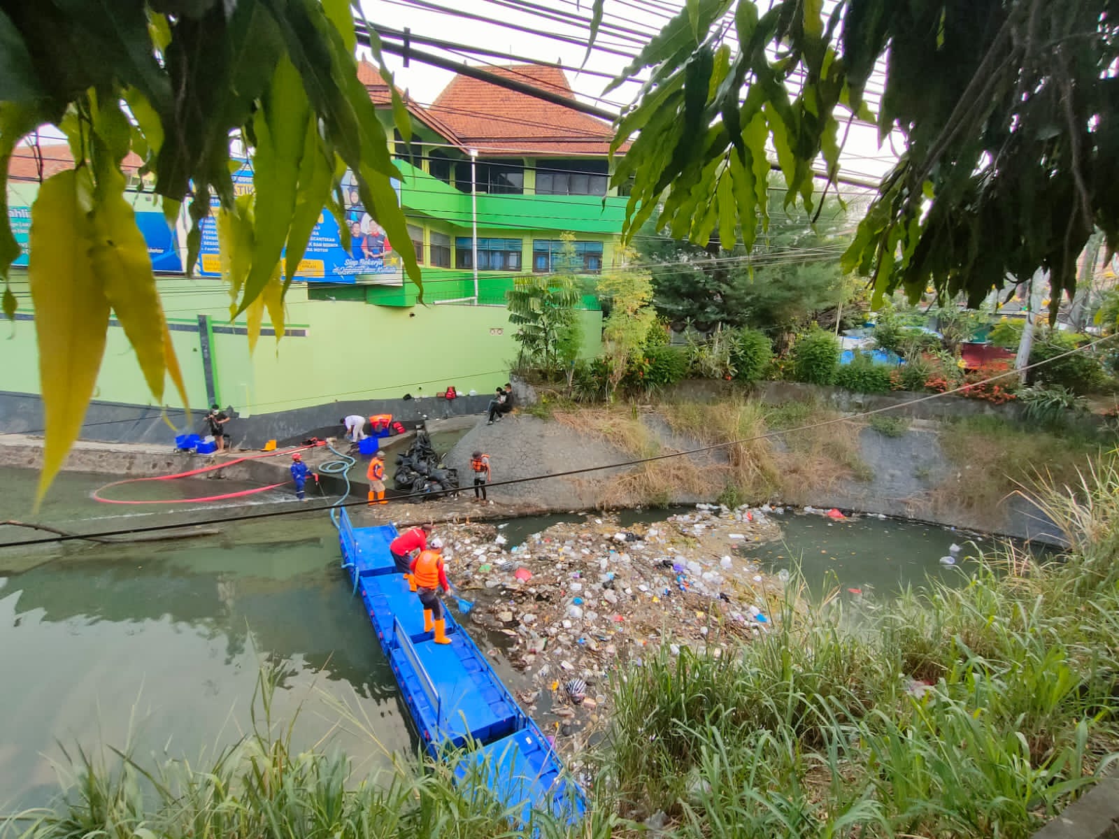 GOTONG ROYONG: Relawan Kelurahan Pajang bersihkan tumpukan sampah di bawah Jembatan Kleco, Sabtu (21/6).