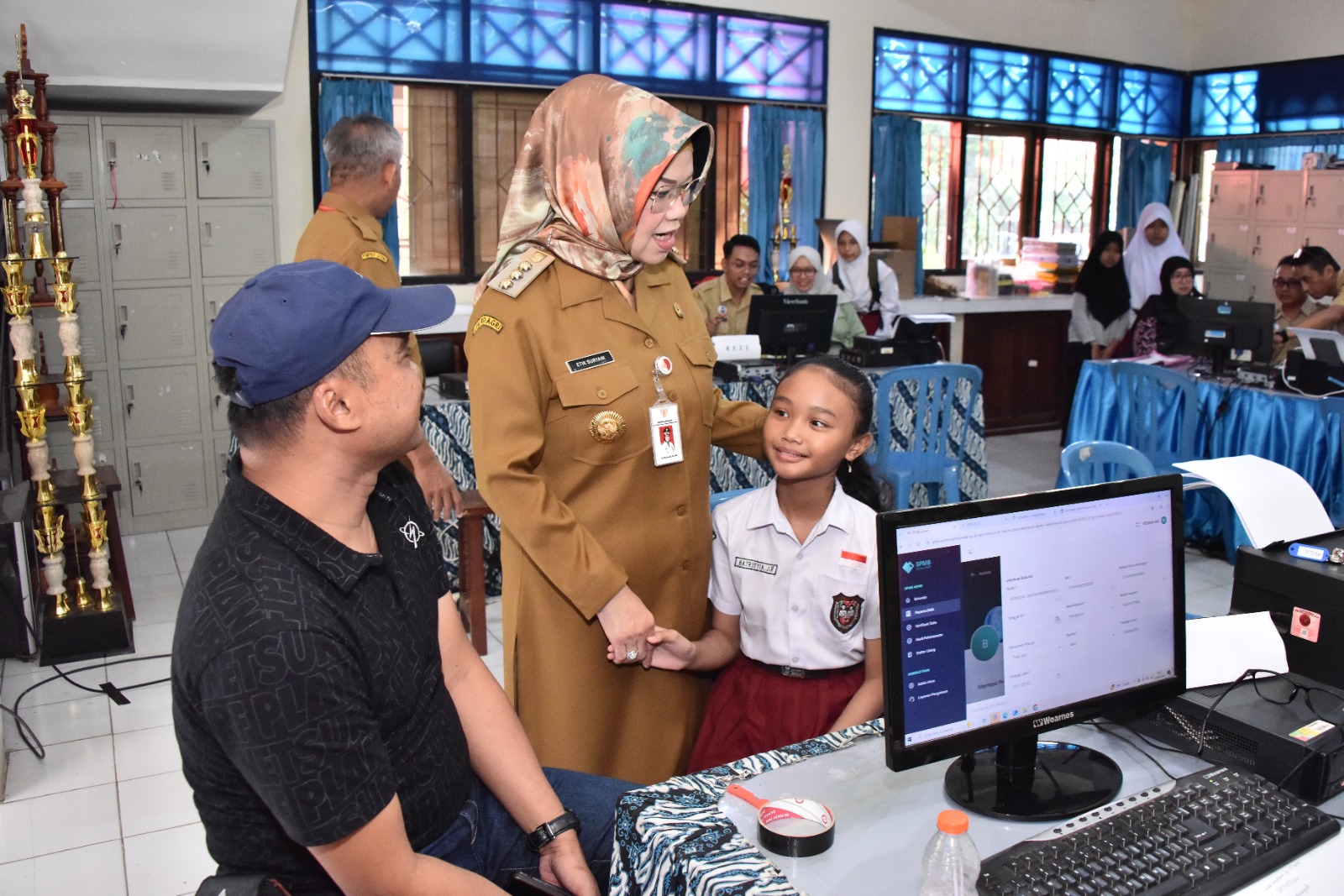 Bupati Etik Sukoharjo berinteraksi dengan siswi SD di sela pendaftaran SPMB. Pemkab Sukoharjo akan meluncurkan program beasiswa kuliah untuk anak-anak dari keluarga tidak mampu namun memiliki prestasi