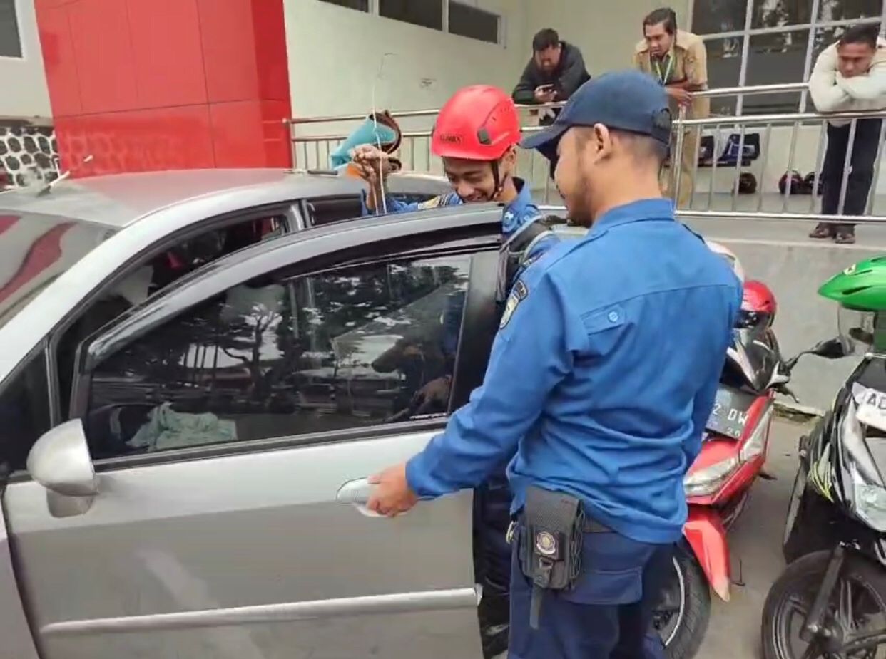 Personel Damkar Boyolali berhasil membuka pintu mobil milik warga Gunung Kidul untuk mengambil kunci yang tertinggal di dalamnya, Senin (30/6/2025).