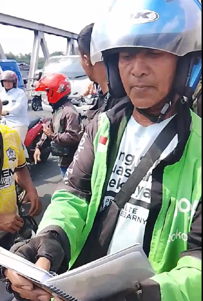 Saksi yang merupakan driver ojol membacakan pesan tulisan tangan dari perempuan yang melompat dari Jembatan Jurug Solo, Selasa (1/7/2025).
