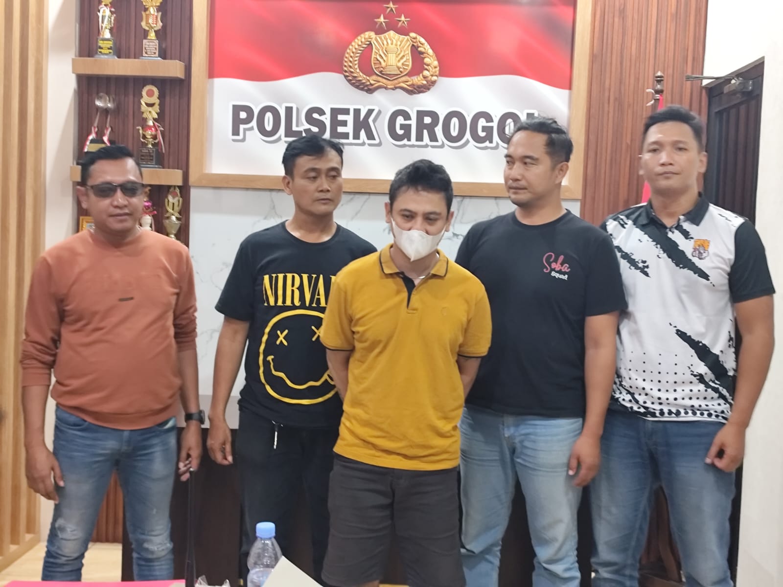 Panji Guruh alias Anji bin Usamah Al Uut (pakai masker) warga Pasar Kliwon, Kota Solo yang mengaku anggota polisi dibekuk. (Iwan Kawul/Radar Solo)