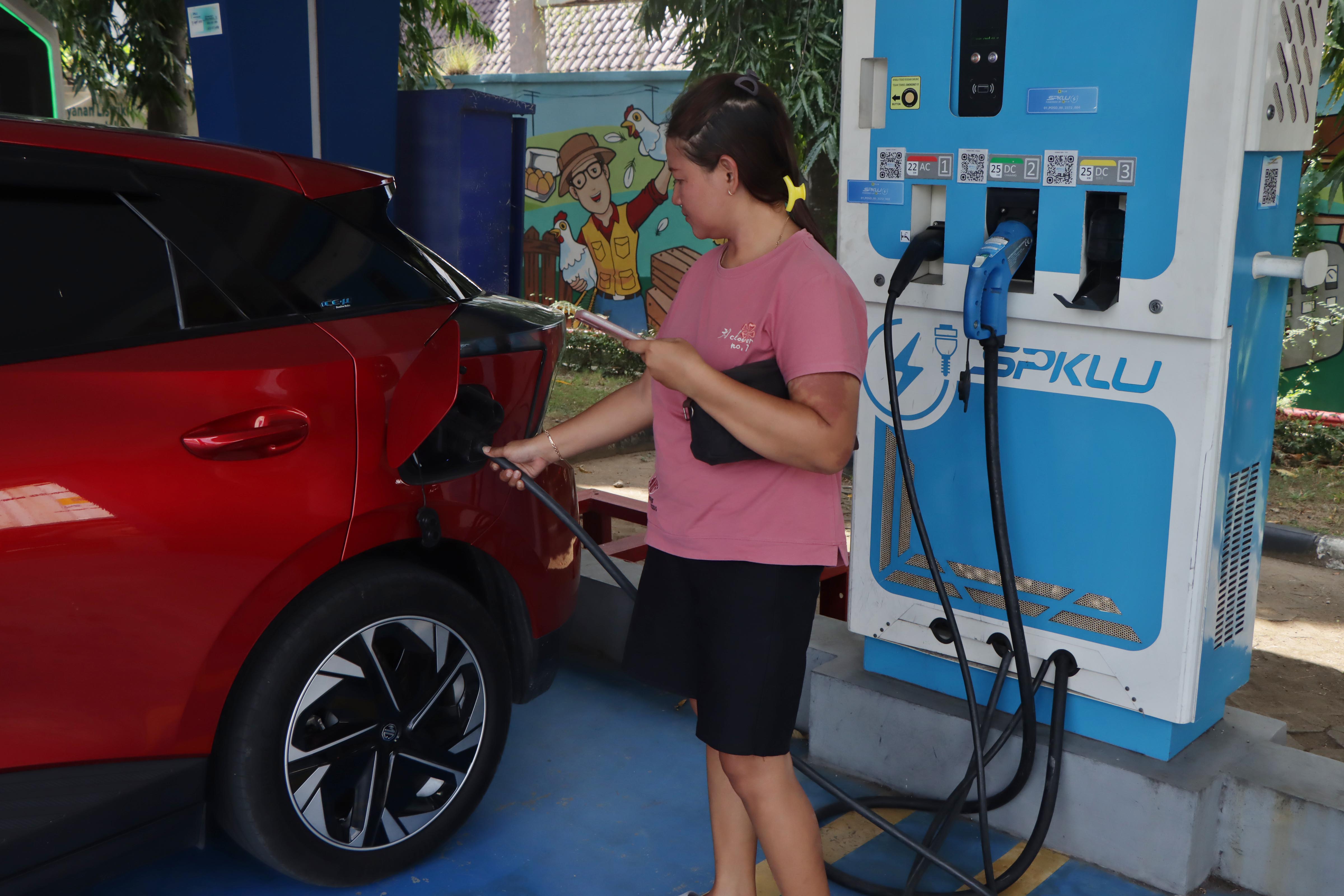 Pemilik mobil listrik sedang mengisi daya di SPKLU PLN Solo. (Arief Budiman/Radar Solo)