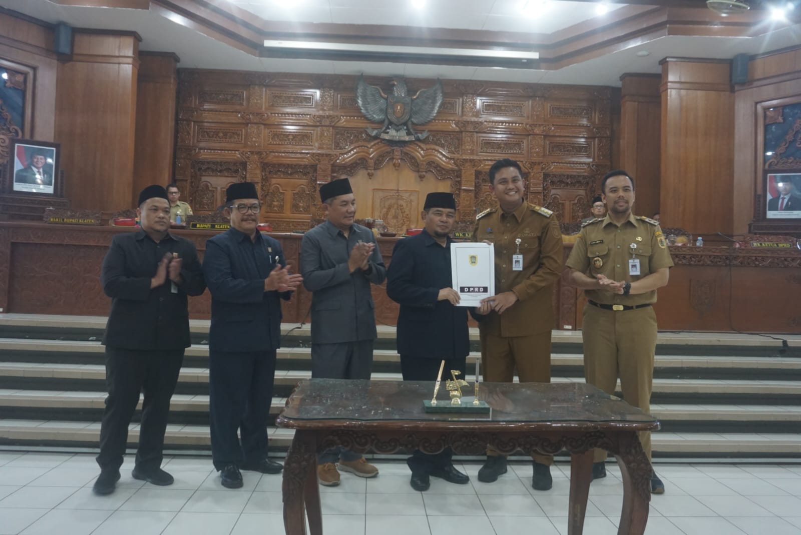 Ketua DPRD Klaten Edy Sasongko saat menyerahkan dokumen persetujuan bersama tiga raperda kepada Bupati Klaten Hamenang Wajar Ismoyo.