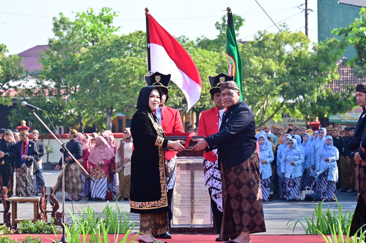 Pj Sekda Sukoharjo Suyamto serahkan petikan Peraturan Pemerintah No 16/SD/1946 tentang berdirinya Kabupaten Sukoharjo kepada Bupati Etik Suryani di Halaman Kantor Setda Sukoharjo, Selasa (15/7/2025).