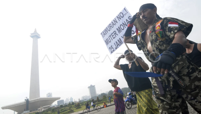 Kopral Bagyo aksi memutar Lapangan Monumen Monas (Monas) sambil memanggul batu di halaman Monas, Jakarta, Sabtu (6/7/2016).