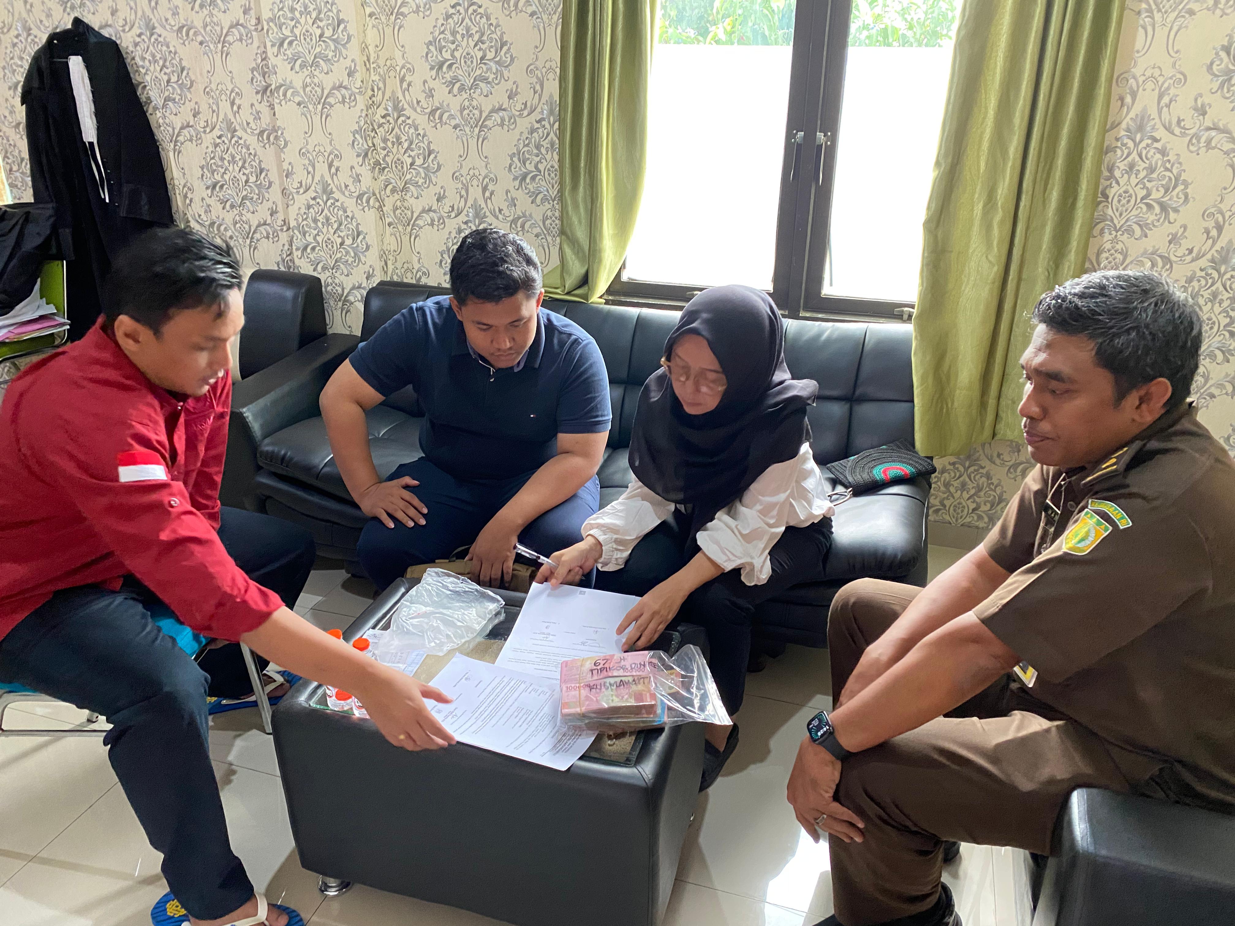 Pegawai Dinkes Karanganyar, Kusmawati (dua dari kanan) serahkan uang ke Kejari Karanganyar, Rabu (16/7/2025). (Rudi Hartono/Radar Solo)